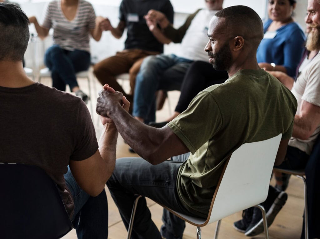 group of people supporting each other through drug addiction treatment